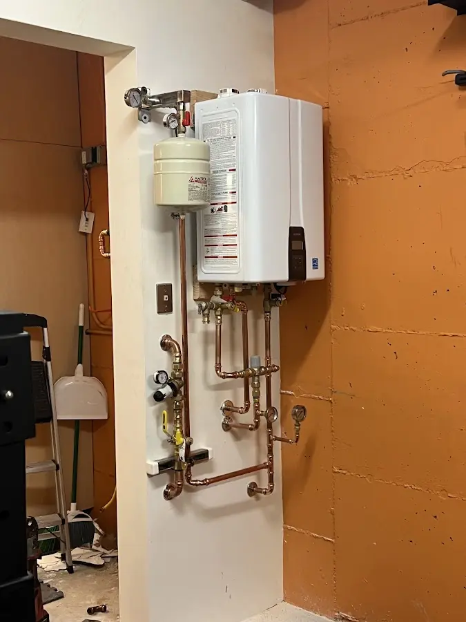 Plumbing technician inspecting water heater connections in Macon